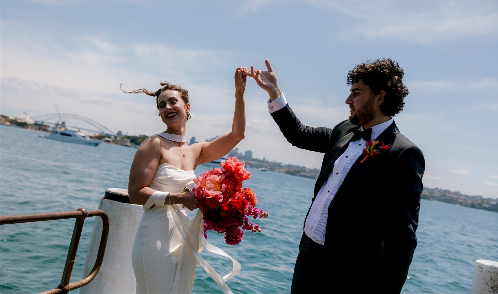 Couple on a boat holding hands with a cityscape in the background